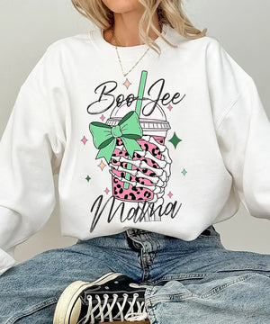 Person wearing white crewneck sweatshirt with a graphic design of a pink drink with a straw and bow, text 'Boo Jee Mama'.