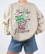 Person wearing sand crewneck sweatshirt with a graphic design of a pink drink with a straw and bow, text 'Boo Jee Mama'.